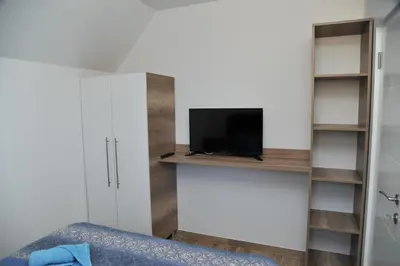 a bedroom with a bed and a tv on a shelf at Apartmani Krstojević Kopaonik in Kopaonik