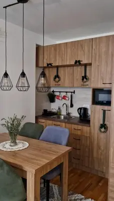 a kitchen with wooden cabinets and a wooden table at Apartman MonTanja Kopaonik, u hotelu Kraljevi Čardaci in Kopaonik