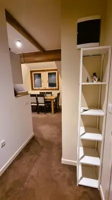 a room with a book shelf and a dining room at FEMI Kopaonik Apartment, Župa Aparthotel, Kopaonik Center in Kopaonik