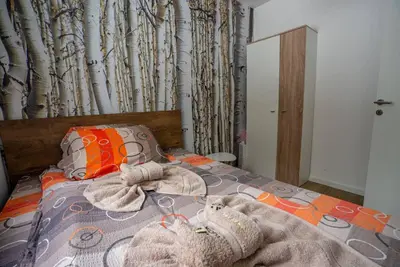 a bedroom with a bed with towels on it at Apartman Lucky 2 Kopaonik in Kopaonik