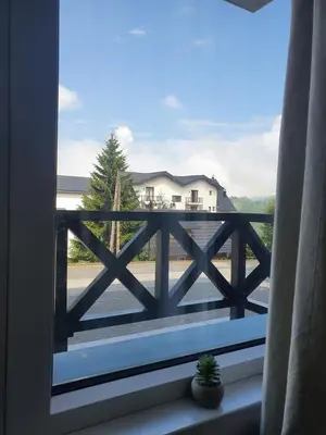 a window with a view of a house at Apartman Lucky 2 Kopaonik in Kopaonik