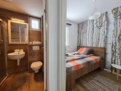 a small bathroom with a bed and a sink at Apartman Lucky 2 Kopaonik in Kopaonik
