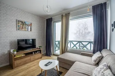 a living room with a couch and a large window at Apartman Lucky 2 Kopaonik in Kopaonik