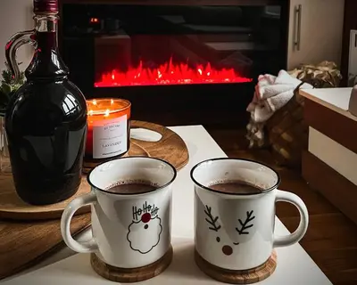 two cups of coffee on a table with a bottle of wine at MIR i LIRA apartmani Kopaonik in Kopaonik