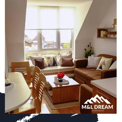 a living room with a couch and a table at MIR i LIRA apartmani Kopaonik in Kopaonik