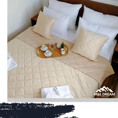 a tray of food on a bed with pillows at MIR i LIRA apartmani Kopaonik in Kopaonik