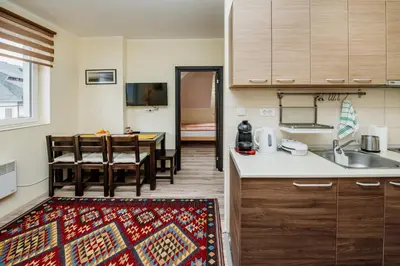 a kitchen and a dining room with a table at Apartman No.32a-JollyKop in Kopaonik