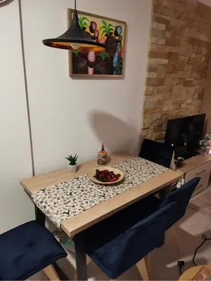 a dining room table with a plate of food on it at Apartman MOUNTAIN VIEW Milmari Resort in Kopaonik