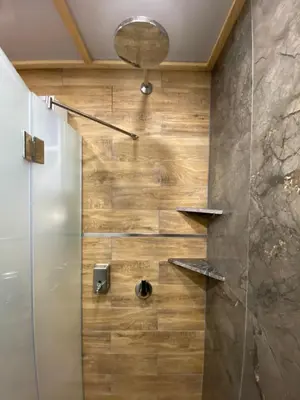 a shower in a bathroom with a wooden wall at Apartman Pod bregom - Gondola 180m in Brzeće