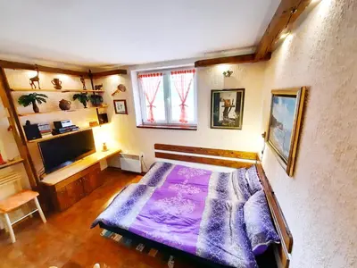 a bedroom with a large purple bed in a room at Apartman Pod bregom - Gondola 180m in Brzeće
