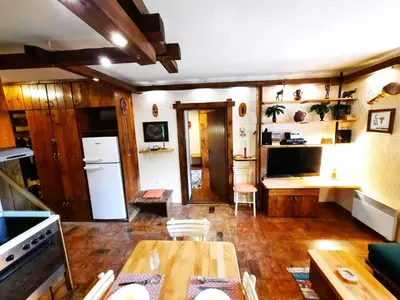 a living room with a table and a kitchen at Apartman Pod bregom - Gondola 180m in Brzeće