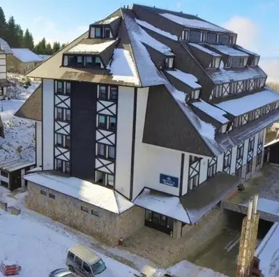a large building with snow on the roof at Luna Apartman, Župa Kopaonik in Kopaonik