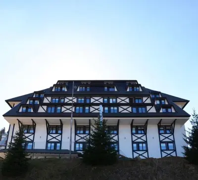 a large white building with a lot of windows at Luna Apartman, Župa Kopaonik in Kopaonik