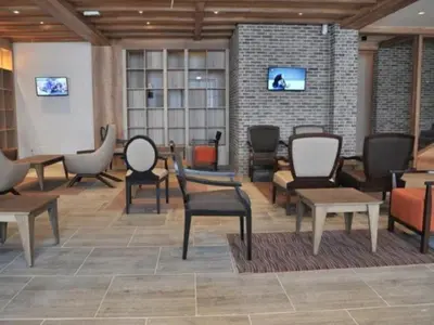 a waiting room with chairs and tables and televisions at Lola Apartment - Župa, Kopaonik in Kopaonik