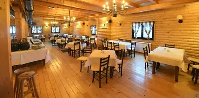 a room with tables and chairs in a restaurant at Lola Apartment - Župa, Kopaonik in Kopaonik