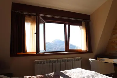 a bedroom with a window with a view of a mountain at Apartman Snesko Zoned in Kopaonik