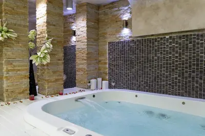 a large bath tub in a bathroom with brick walls at Apartman Snesko Zoned in Kopaonik