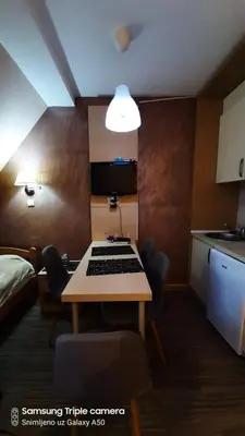 a small room with a table and a kitchen at S Konaci in Kopaonik