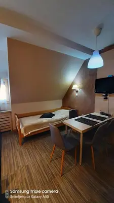 a hotel room with a bed and a table and chairs at S Konaci in Kopaonik