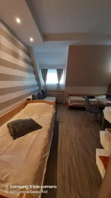 a hotel room with a bed and a table and chairs at S Konaci in Kopaonik