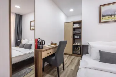 a bedroom with a desk and a bed and a chair at Vila Greta by Hotel Ramonda in Rtanj