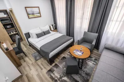 a bedroom with a bed and a table and a couch at Vila Greta by Hotel Ramonda in Rtanj