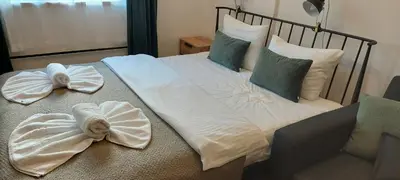 a bed with white sheets and towels on it at Milmari ApartmanVid N57 in Kopaonik