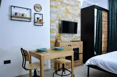 a room with a table and two chairs and a tv at Milmari ApartmanVid N57 in Kopaonik