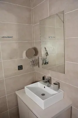 a bathroom with a white sink and a mirror at Milmari ApartmanVid N57 in Kopaonik