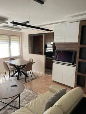a living room with a table and a kitchen at Aleksinac in Aleksinac
