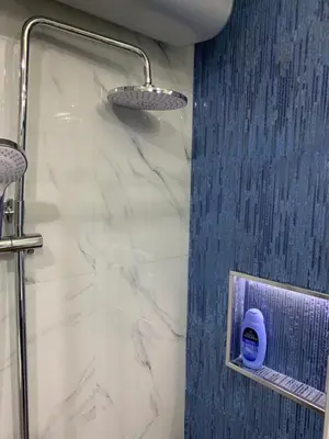 a bathroom with a shower with a blue and white marble at Aleksinac in Aleksinac