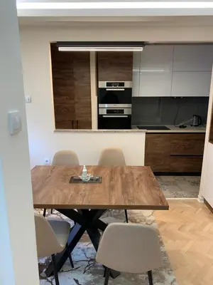 a kitchen with a wooden table and chairs at Aleksinac in Aleksinac