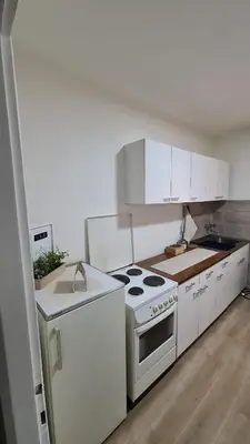 a kitchen with white cabinets and a stove top oven at Apartman Pavlovic in Leskovac