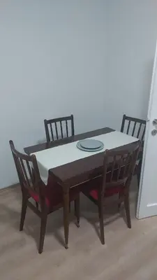 a wooden table with two chairs and a plate on it at Apartman Pavlovic in Leskovac