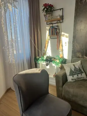a living room with a chair and a couch and a window at Pogled iznad oblaka in Kopaonik