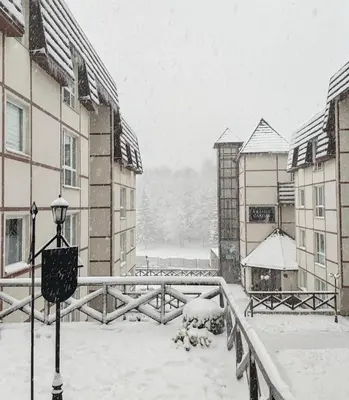 a courtyard covered in snow with buildings and a street light at Kraljevi Cardaci Olja in Kopaonik