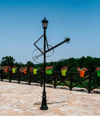 a street light in front of a fence with flowers at Kraljevi Cardaci Olja in Kopaonik