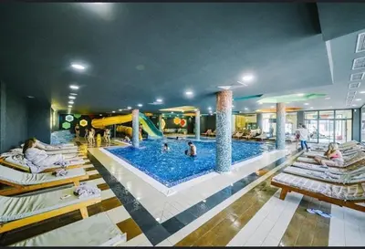 a large swimming pool in a hotel with people in it at Kraljevi Cardaci Olja in Kopaonik