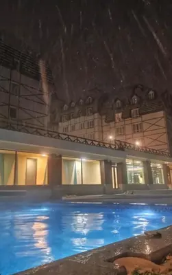 a swimming pool in front of a building at night at Kraljevi Cardaci Olja in Kopaonik