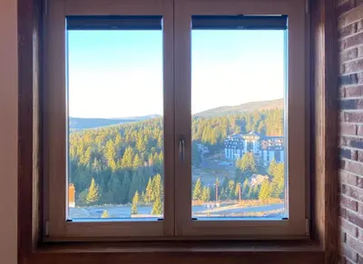 a window with a view of a mountain at Apartman Sky View, Župa Wellness & Spa u Centru Kopaonika in Kopaonik