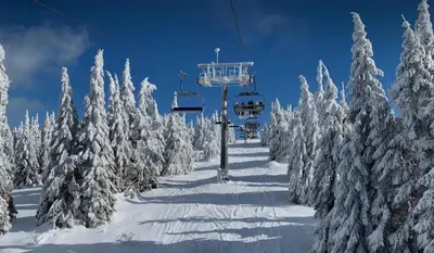 a ski lift in the middle of a snow covered forest at Apartman Sky View, Župa Wellness & Spa u Centru Kopaonika in Kopaonik