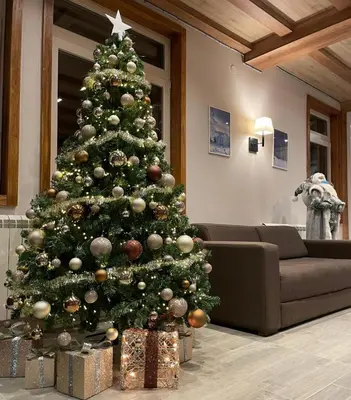 a christmas tree with presents under it in a living room at Apartman Sky View, Župa Wellness & Spa u Centru Kopaonika in Kopaonik
