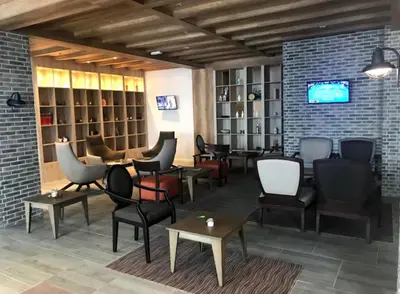a waiting room with chairs and tables and a tv at Apartman Sky View, Župa Wellness & Spa u Centru Kopaonika in Kopaonik