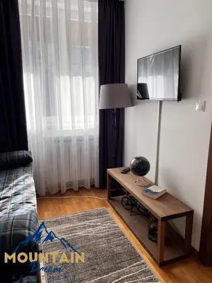 a living room with a table and a tv on a wall at Fully Equiped, Quiet, for 5 persons, Next To Panoramic Gondola in Brzeće
