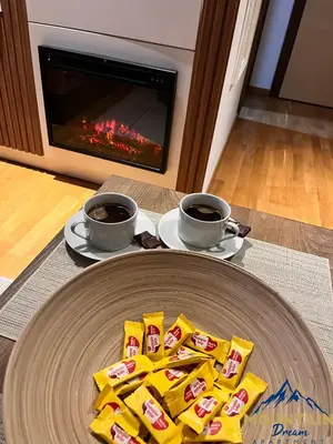 two cups of coffee and packets of food on a table with a fireplace at Fully Equiped, Quiet, for 5 persons, Next To Panoramic Gondola in Brzeće