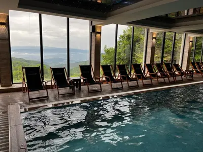 a row of chairs sitting next to a swimming pool at Milmari P74, Quest apartmani, Kopaonik in Kopaonik