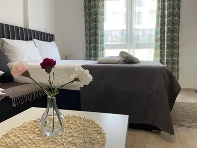 a bedroom with a bed and a vase with flowers on a table at Milmari P74, Quest apartmani, Kopaonik in Kopaonik
