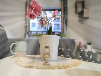 a table with two mugs and a vase with flowers at Milmari P74, Quest apartmani, Kopaonik in Kopaonik