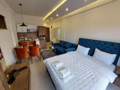 a bedroom with a large bed with a blue headboard at N-delux apartman in Kopaonik