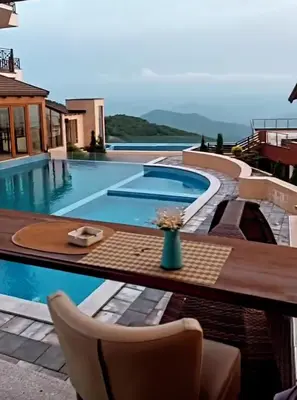 a swimming pool with a vase of flowers on a table at N-delux apartman in Kopaonik